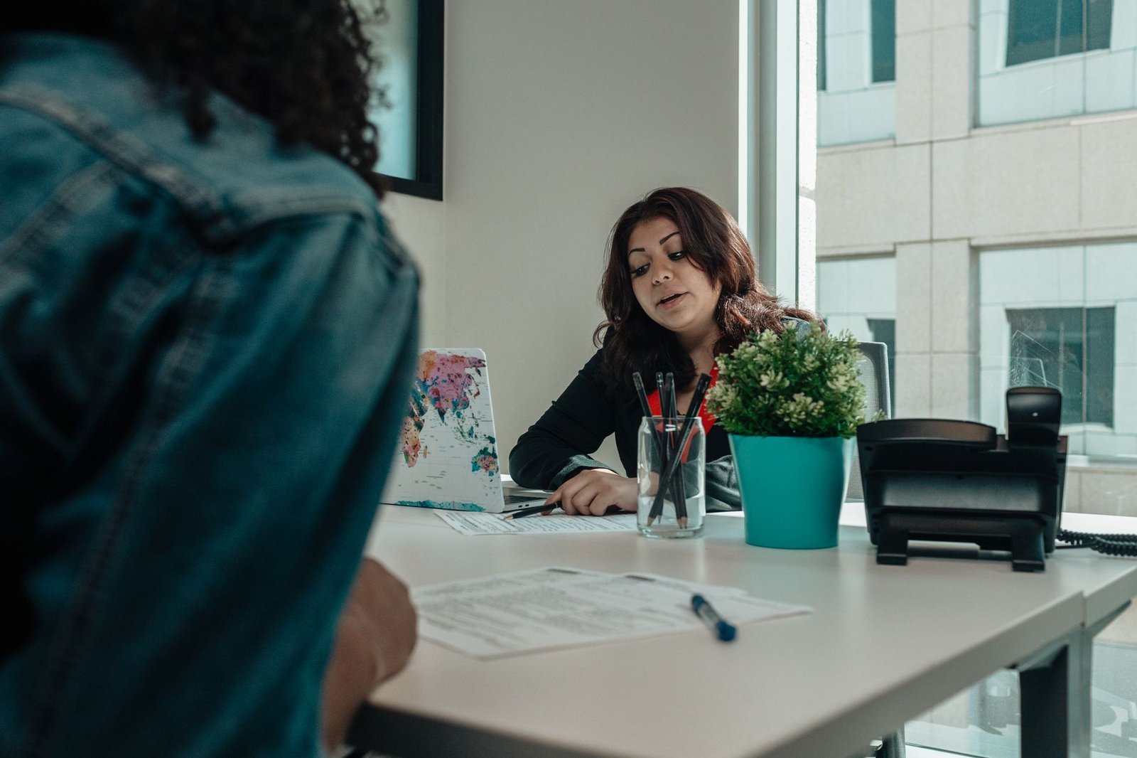 Two people talking calmly at a table with paperwork, representing patient rights in inpatient mental health care